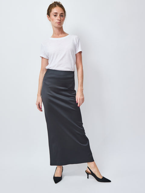 Woman wearing a white t-shirt and black skirt on a white background
