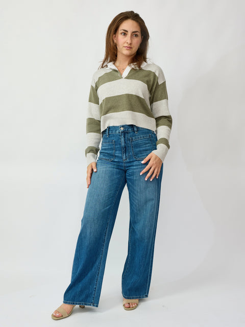 Woman wearing a striped shirt and blue jeans on a white background