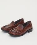 Brown leather kiltie loafers with a tassel fringe and low block heels.