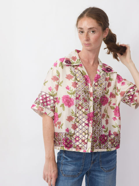 Woman wearing a floral patterned shirt with a white background