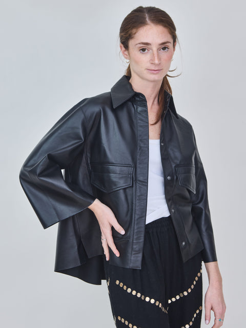 Woman wearing a black leather jacket on a plain background