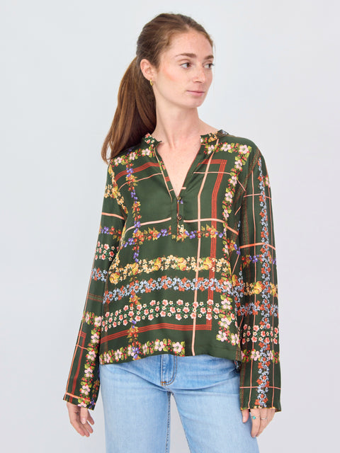 Woman wearing a patterned blouse with a plain background
