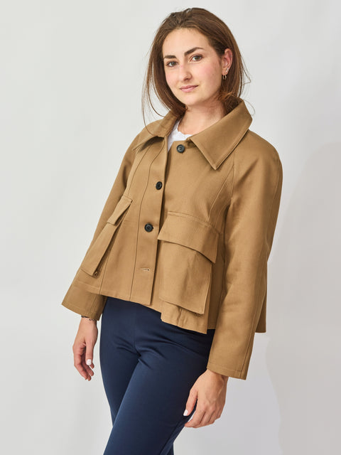 Woman wearing a tan jacket on a plain background