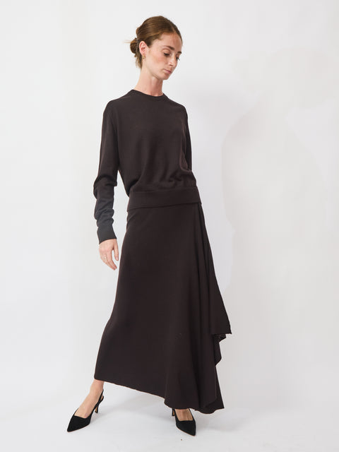 Woman wearing a black sweater and black skirt on a white background
