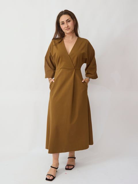 Woman wearing a brown dress against a white background