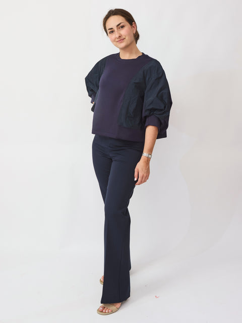 Woman wearing a navy blue outfit on a white background