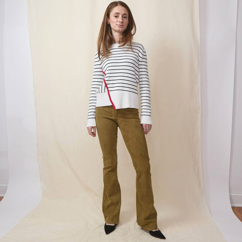 Beautiful woman wears brown flare suede pants with black and white striped sweater and black pointy slingbacks