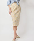 Light beige midi skirt with subtle floral jacquard pattern and fitted silhouette.