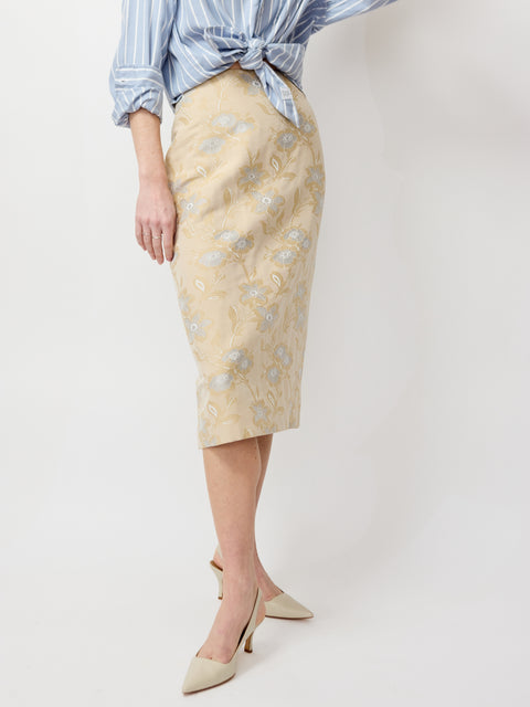 Light beige midi skirt with subtle floral jacquard pattern and fitted silhouette.