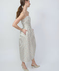 Sleeveless midi dress with a fitted bodice and flared skirt in light fabric with small floral pattern, clementine color.