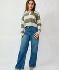 Woman wearing a striped shirt and blue jeans on a white background