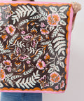 Person holding a floral and butterfly patterned fabric against a white background