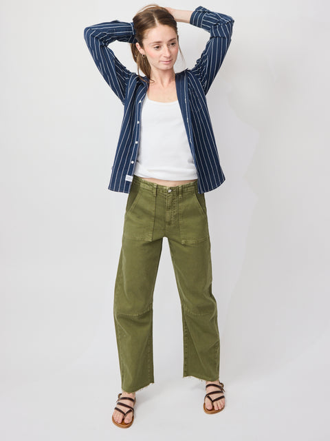 Olive green denim utility soft barrel pants with a relaxed fit, paired with a white tank and navy striped shirt.