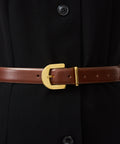 Mahogany leather belt with gold buckle and gold loop on black garment.