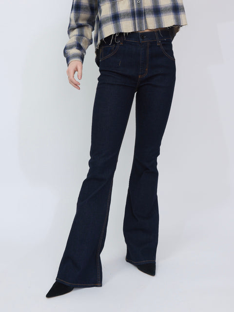 High-waisted indigo denim jeans with a flared leg and classic five-pocket design, worn with a plaid shirt and black pointed.