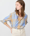 Loose-fit button-up shirt in camel and light blue check pattern with rolled-up sleeves.