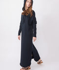Long British navy hooded dress with long sleeves and side slits, worn with sandals.