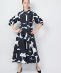 Black, white, and navy midi dress with bold graphic floral print and puffed elbow-length sleeves.