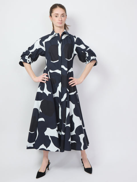 Black, white, and navy midi dress with bold graphic floral print and puffed elbow-length sleeves.