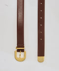 Mahogany leather belt with gold buckle and gold tip, featuring multiple adjustment holes.