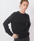 Person wearing a black sweater on a white background