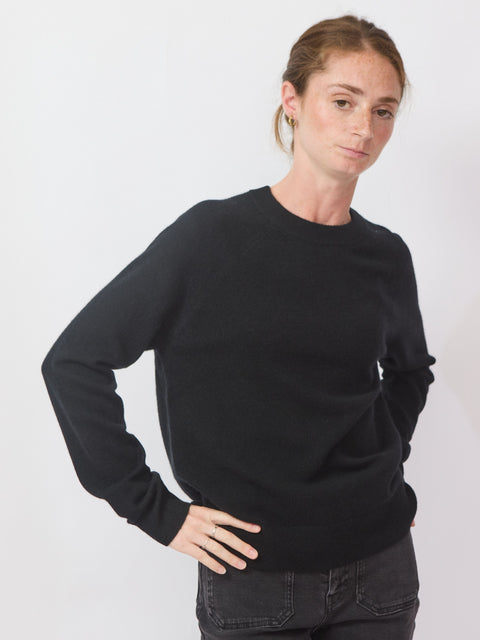 Person wearing a black sweater on a white background