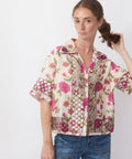 Woman wearing a floral patterned shirt with a white background
