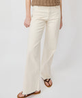 High-waisted bone-colored denim jeans with a straight column fit, worn with brown sandals.