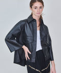 Woman wearing a black leather jacket on a plain background