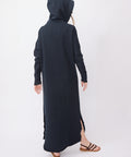Long British navy dress with a hood, long sleeves, side slits, and a relaxed fit, paired with flat sandals.