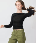 Black long-sleeve fitted t-shirt with a round neckline worn tucked into olive green cargo pants.