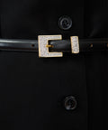 Black leather belt with rectangular gold-tone buckle encrusted with small crystals.