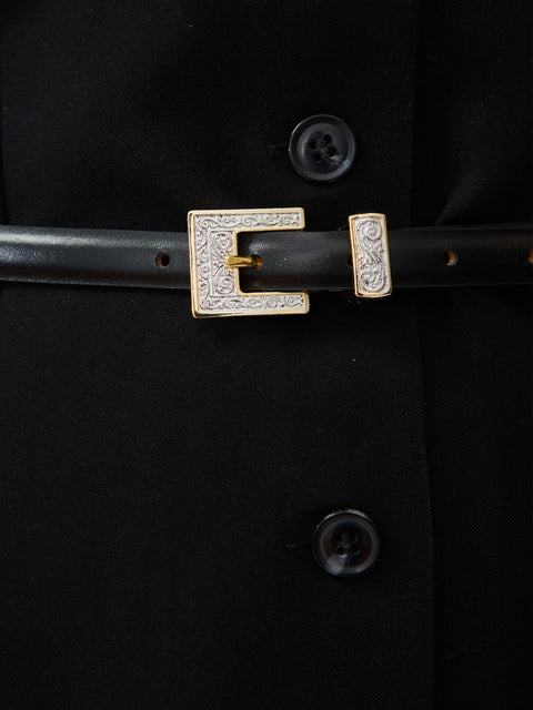 Black leather belt with rectangular gold-tone buckle encrusted with small crystals.