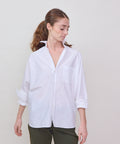 White long-sleeve button-up shirt with relaxed fit and classic collar on a model.