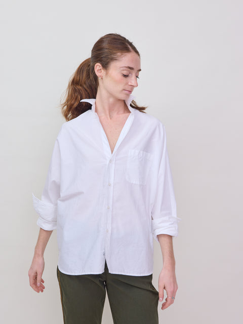 White long-sleeve button-up shirt with relaxed fit and classic collar on a model.