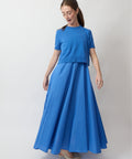 Blue short-sleeve maxi dress with layered bodice and flowy skirt worn with beige heels.