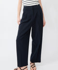 Navy wide-leg pants with high waist and front pockets, worn with striped top and sandals.