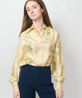 Cream satin blouse with colorful floral embroidery and long puffed sleeves.