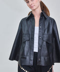 Woman wearing a black leather jacket on a plain background