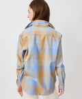 Long-sleeve button-up shirt with camel and blue plaid pattern, relaxed fit, and curved hem.