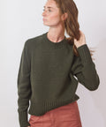 Woman wearing a green sweater against a white background