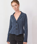 Woman wearing a blue blazer over a black top on a white background