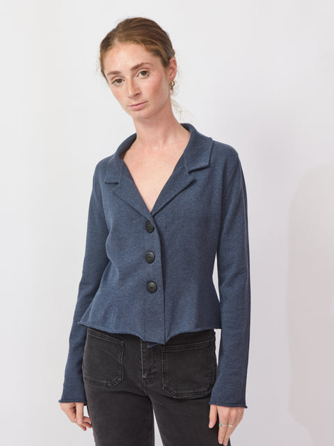 Woman wearing a blue blazer over a black top on a white background