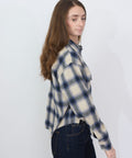 Purple and cream plaid flannel shirt with long sleeves and button-down front.