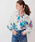 Woman wearing a floral blouse and jeans on a white background