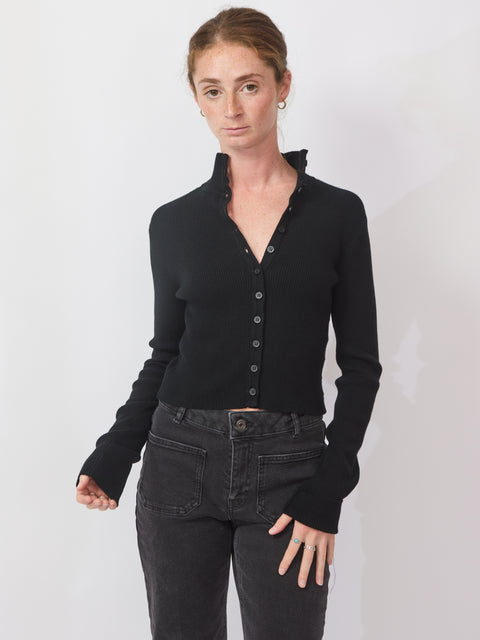 Person wearing a black long-sleeve shirt and black pants on a white background