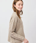 Light beige knit sweater with textured pattern and relaxed fit on a female model.