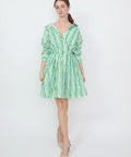 Green and white striped off-shoulder mini dress with cinched waist and long sleeves.