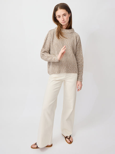 Light beige cable knit turtleneck sweater with relaxed fit and long sleeves.
