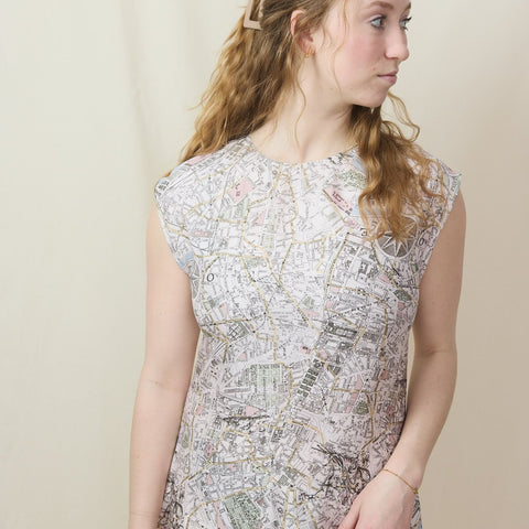 Young blond wears a sleeveless silk midi dress in a Paris map print.